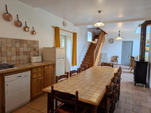 a kitchen and dining room with a table and chairs at Gîte calme en forêt, proche Gien, 3 chambres et 2 salles d'eau - FR-1-590-555 in Ouzouer-sur-Trézée