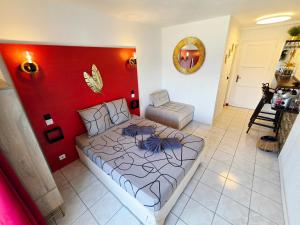 ein Schlafzimmer mit einem Bett und einer roten Wand in der Unterkunft Sweet Crépuscule - Studio avec Vue Mer Imprenable & Piscine in Les Trois-Îlets