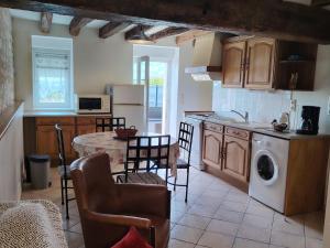 eine Küche mit einem Tisch und Stühlen in einer Küche in der Unterkunft Maison au cœur du Berry : tranquillité, jeux pour enfants et proche Château de Valençay et Zoo de Beauval - FR-1-591-235 in Frédillé