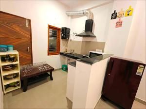 a kitchen with a counter and a sink and a refrigerator at A2 Vista - 4BHK Villa with Lawn Near Expo Mart in Greater Noida +20 photos