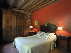ein Schlafzimmer mit einem weißen Bett und einer roten Wand in der Unterkunft Maison Rustique Familiale en Sologne avec Grands Espaces, Proche Châteaux de la Loire - FR-1-590-1 in Ardon