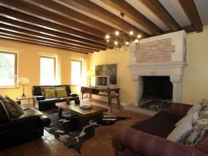 ein Wohnzimmer mit Couch und Kamin in der Unterkunft Maison Rustique Familiale en Sologne avec Grands Espaces, Proche Châteaux de la Loire - FR-1-590-1 in Ardon