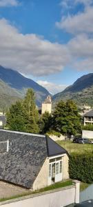 ein Haus mit einem Dach mit Bergen im Hintergrund in der Unterkunft Appartement cosy Luz-St-Sauveur Ski et randonnée in Luz-Saint-Sauveur