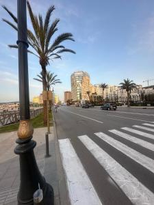 a street light on the side of a road with palm trees at Abu Issa Hostel Tangier in Tangier