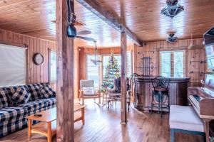 - un salon avec un canapé et un arbre de Noël dans l'établissement Sous Bois & Loft - Hot tub - Ski out, à Saint-Faustin–Lac-Carré