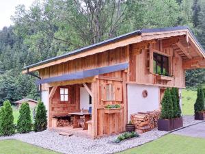 un gran edificio de madera con una mesa de picnic. en Almversteck Hollersbach, en Hollersbach im Pinzgau
