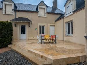 a patio with chairs and tables in front of a house at Maison confortable avec accès jardin et étangs, proche Sologne et Châteaux de la Loire - FR-1-591-555 in Reboursin