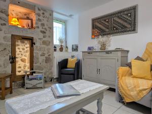 ein Wohnzimmer mit Sofa und Tisch in der Unterkunft Gîte de charme en Auvergne, cour fermée, jardins privés, BBQ, babyfoot, proche St Jacques de Compostelle - FR-1-582-232 in Saint-Georges-Lagricol
