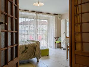 ein Schlafzimmer mit einem Bett und einem großen Fenster in der Unterkunft Gîte de charme en Auvergne, cour fermée, jardins privés, BBQ, babyfoot, proche St Jacques de Compostelle - FR-1-582-232 in Saint-Georges-Lagricol