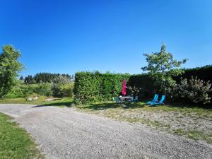 deux chaises et une table sur le côté d'une route en gravier dans l'établissement Gîte de charme en campagne, 5-8 pers., cheminée, nature, proche Pilat, activités à proximité - FR-1-582-269, à Saint-Romain-Lachalm 3 autres photos