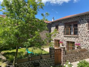 a stone house with a tree in front of it at Gîte à la ferme à Saint-Christophe-sur-Dolaison avec terrasse et chambres privatives - FR-1-582-284 in Saint-Christophe-sur-Dolaison