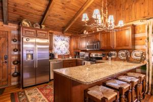 eine Küche mit Holzschränken und einem Edelstahlkühlschrank in der Unterkunft Riverdale in Boone