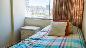 a small bedroom with a bed with a window at Ocean Front House 84 in Viña del Mar