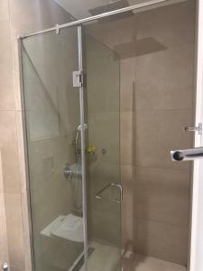 a shower with a glass door in a bathroom at Executive studio at East Legon in Accra