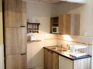 une petite cuisine avec un évier et un réfrigérateur dans l'établissement Gîte paisible dans la nature près de Chartres - FR-1-581-142, à Saint-Symphorien 9 autres photos