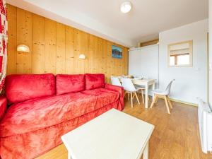 a living room with a red couch and a table at Appartement 6 pers aux pieds des pistes à Saint-François-Longchamp - FR-1-807-29 in Saint-François-Longchamp