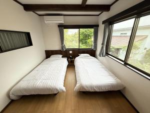 deux lits dans une chambre avec deux fenêtres dans l'établissement grand view minamihakone - Vacation STAY 19731, à Atami