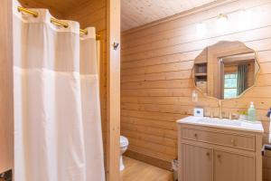 ein Badezimmer mit Duschvorhang und Waschbecken in der Unterkunft Queen Ridge Cabin in West Jefferson + 35 Fotos