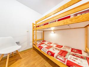 a bedroom with two bunk beds and a white chair at Appartement 6 pers, pieds des pistes, St-François-Longchamp - FR-1-807-105 in Saint-François-Longchamp