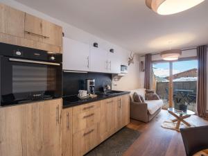 eine Küche mit Holzschränken und ein Wohnzimmer in der Unterkunft Appartement charmant 4 pers, piste proche, parking, Les Saisies - FR-1-809-13 in Les Saisies