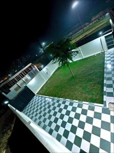 Blick auf einen schachbrettartig gemusterten Boden mit einem Baum auf einem Feld in der Unterkunft A2 Vista - 4BHK Villa with Lawn Near Expo Mart in Greater Noida