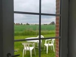 a view of a table and chairs through a window at Gîte 1 Les Ratys : charme, calme et confort près d'Orléans - FR-1-590-523 in Chaingy
