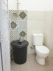 baño con aseo y cubo de basura en Reza Kost, en Karanganyar