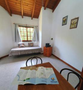 une pièce avec une table, des chaises et une fenêtre dans l'établissement Cabañas Pioneras, à Villa Rumipal