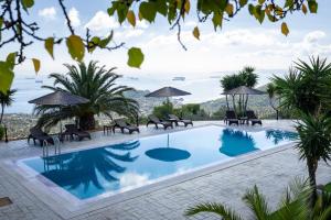 una piscina con sillas y sombrillas en un resort en Prosili, en Aiándion