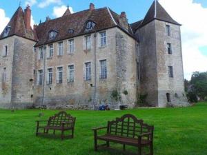 two benches sitting in front of an old building at Gîte indépendant avec étang - 3 chambres, animaux admis - FR-1-583-382 in Gy