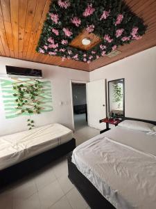 a bedroom with two beds and flowers on the ceiling at Rodadero Parador, apartamentos a 20 metros de la playa in Santa Marta
