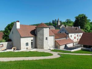 un groupe de bâtiments avec une église en arrière-plan dans l'établissement Gîte de charme rénové avec cheminée à Fondremand - FR-1-583-422, à Fondremand
