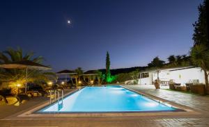 una piscina en un complejo por la noche en Prosili, en Aiándion 1 foto más