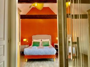 um quarto com uma cama com uma parede laranja em Theven Plages em Santec mais 52 fotografias