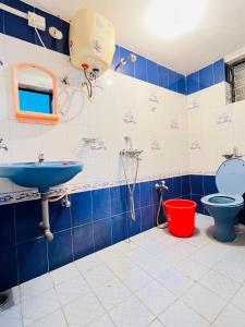 a blue and white bathroom with a sink and a toilet at Mayelle Agonda in Agonda
