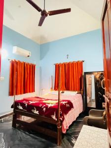 a bedroom with a bed with red curtains at Mayelle Agonda in Agonda