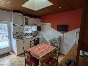 une petite cuisine avec une table et une table et des chaises dans l'établissement Gîte rustique avec salle de jeux et animaux en campagne - FR-1-426-336, à Saint-Julien-des-Landes