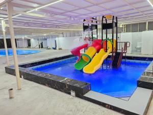 um ginásio com piscina e parque infantil em فيلا جار القمر اطلاله بحرية Near Moon Sea View em Jidá