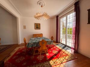 une salle à manger avec une table et une grande fenêtre dans l'établissement Villa des sources en bord de Seine, à La Celle-sur-Seine