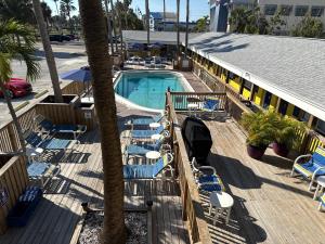 a swimming pool with lounge chairs and a palm tree at Barefoot Bay Resort Motel in Clearwater Beach