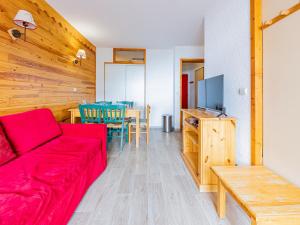 a living room with a red couch and a table at Appartement cosy 6 pers au pied des pistes - FR-1-807-1 in Saint-François-Longchamp