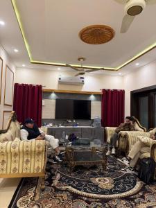 eine Gruppe von Personen, die in einem Wohnzimmer auf Sofas sitzen in der Unterkunft Aolai hotel in Islamabad + 10 Fotos