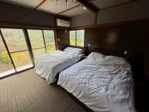 zwei Betten in einem Zimmer mit zwei Fenstern in der Unterkunft Boogie Garden - Vacation STAY 06312v in Miyakami