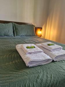a bed with three towels on top of it at Recanto Bamboo Verde in Torres