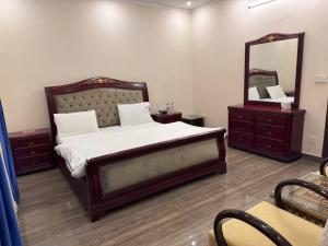 ein Schlafzimmer mit einem großen Bett und einem Spiegel in der Unterkunft Aolai hotel in Islamabad