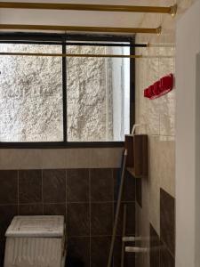 a bathroom with a window and a tiled wall at Rodadero Parador, apartamentos a 20 metros de la playa in Santa Marta