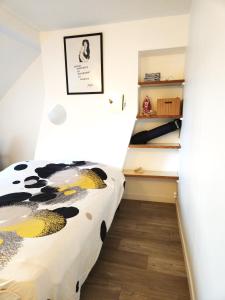 une chambre avec un lit avec un imprimé de vache dessus dans l'établissement Le Duplex de Trouville - central - gare - commerces - marché, à Trouville-sur-Mer