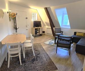 un salon avec une table, des chaises et un canapé dans l'établissement Le Duplex de Trouville - central - gare - commerces - marché, à Trouville-sur-Mer