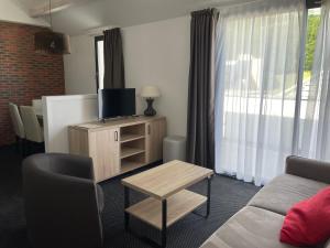 a living room with a tv and a couch and a table at Studio 6 pers, piscine, animaux admis - FR-1-860-28 in Gourette