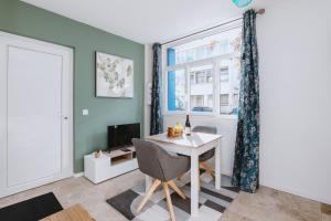 a living room with a table and a window at Romance Bleue -Love Room -SPA privatif - Netflix -séjour à vichy in Vichy